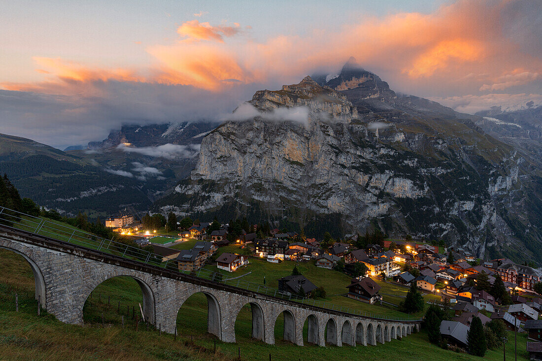 Sonnenuntergang über dem Dorf Murren und der Allmendhubel-Seilbahn auf dem steilen Grat, Lauterbrunnen, Berner Oberland, Schweiz