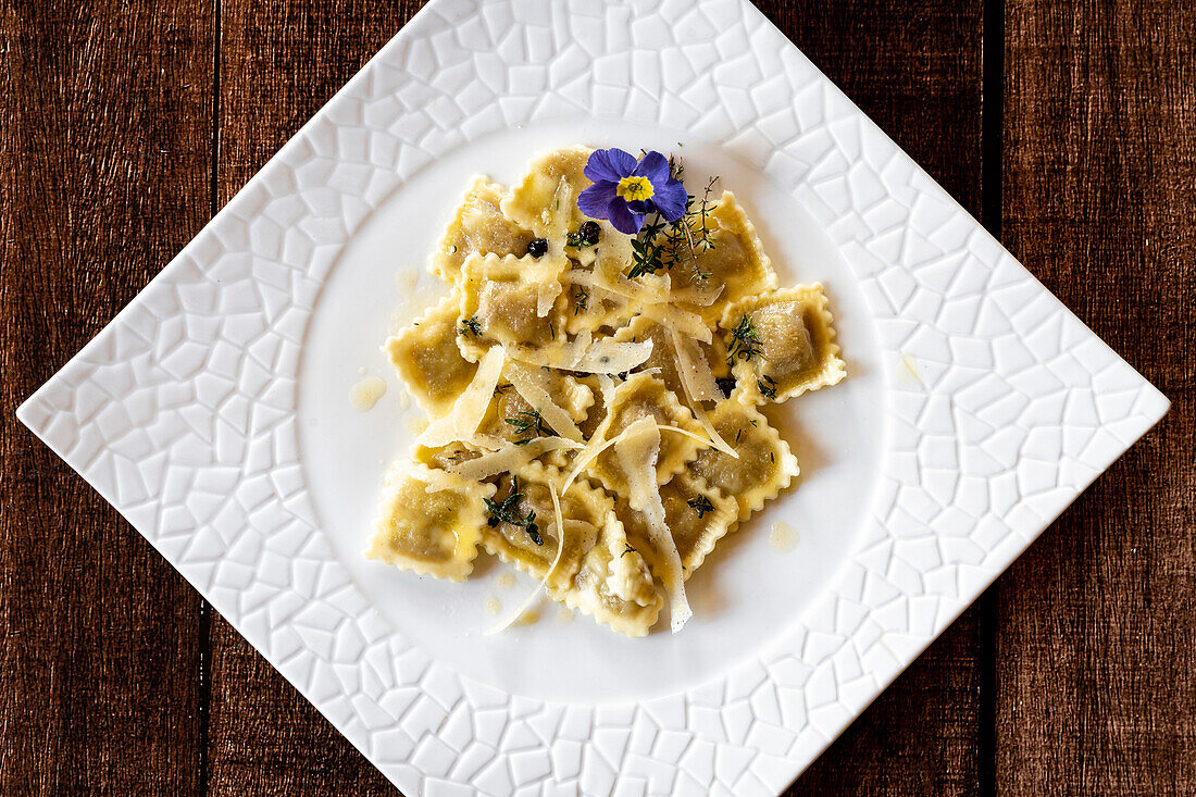 Ravioli traditional pasta stuffed with game meat in white dish from above