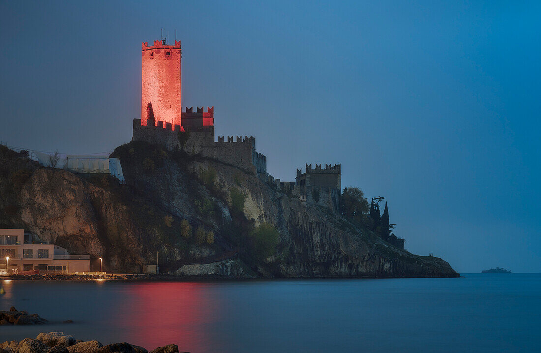 The illuminated tower of Malcesine Scaligero Castle for the night, on the fortress in the Garda lake, Verona, Veneto, Italy