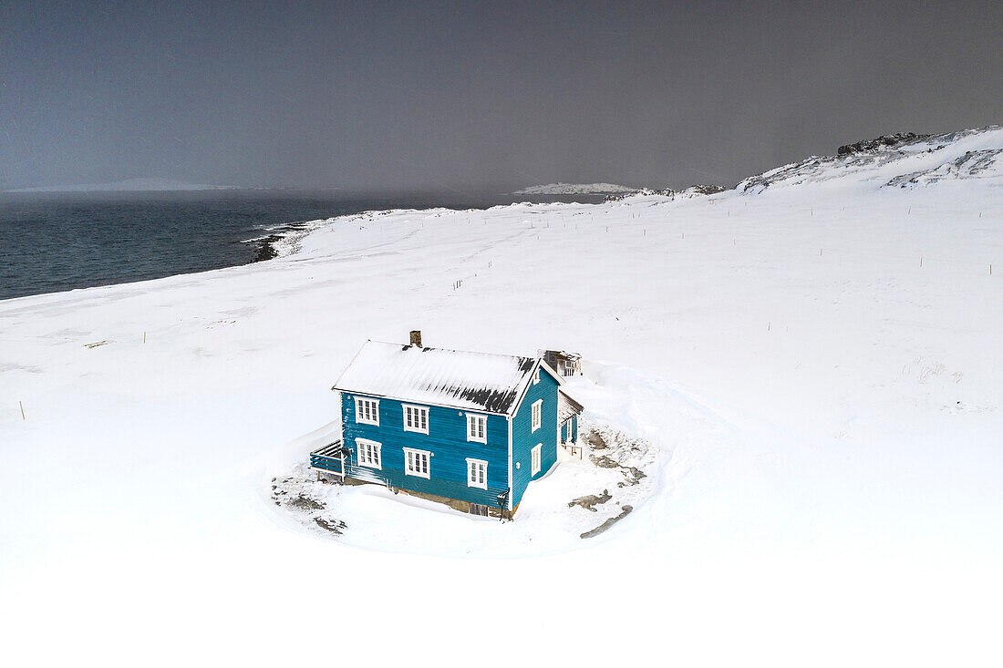 Isoliertes Haus in der Schneelandschaft am arktischen Meer, Veines, Kongfjord, Varanger-Halbinsel, Troms og Finnmark, Norwegen