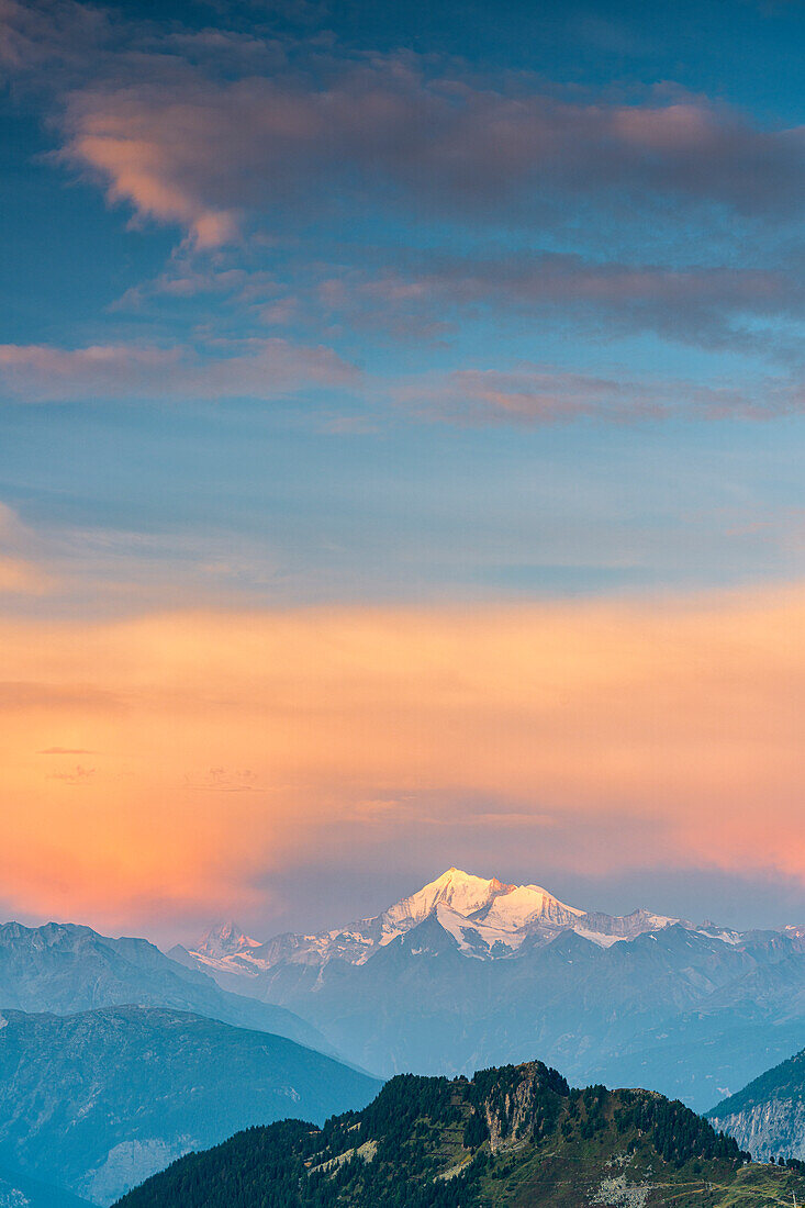 Orange sky at sunrise over Matterhorn and Weisshorn mountain peaks, Pennine Alps, Valais canton, Switzerland