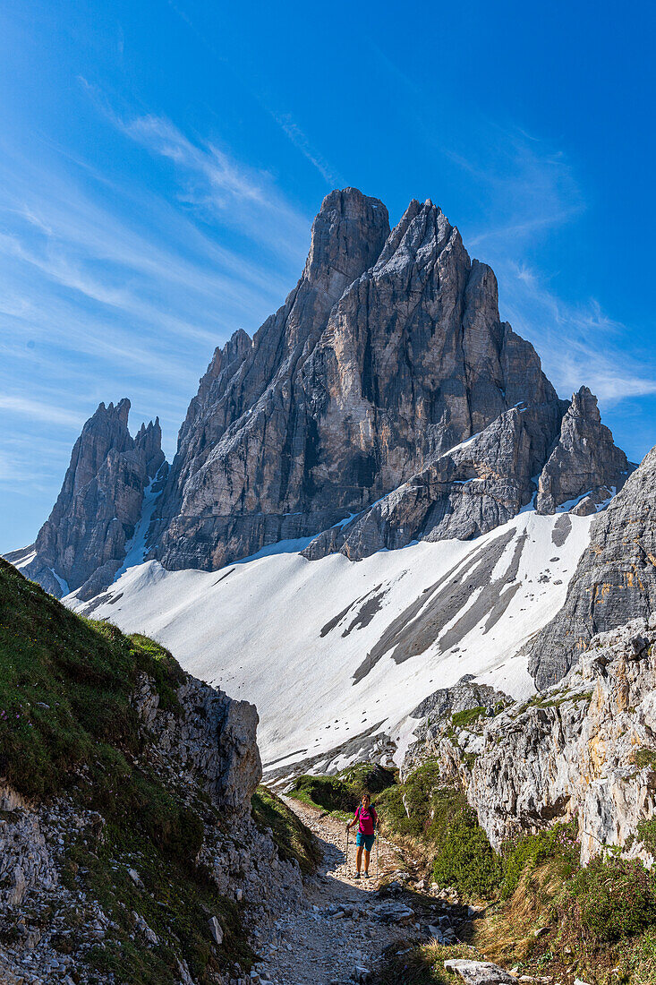 Fröhliche Frau auf Wanderweg mit Croda dei Toni im Hintergrund, Fischleintal, Sextner Dolomiten, Südtirol, Italien