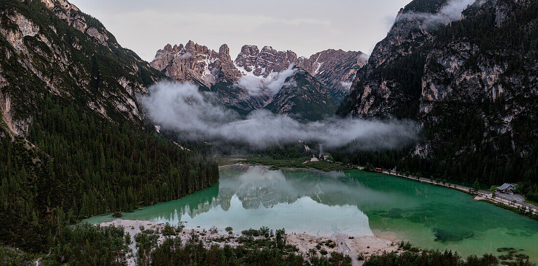 Green woods surrounding lake Landro and Cristallo Popena group at sunset, Dolomites, South Tyrol, Italy