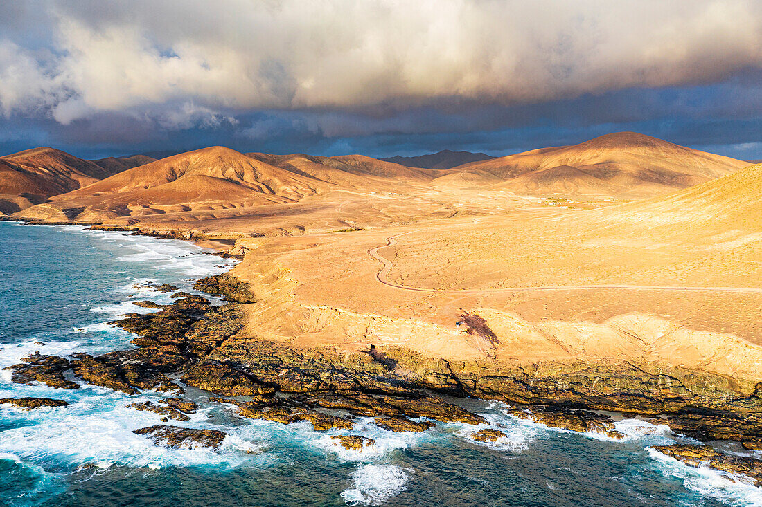 Sunset over desert rocks and Playa de la Solapa beach, aerial view, Atlantic Ocean, Fuerteventura, Canary Islands, Spain