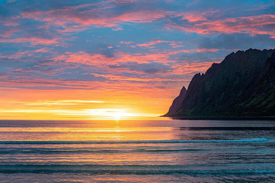 Brennender Himmel über dem arktischen Meer während der Mitternachtssonne, Ersfjord, Senja, Provinz Troms, Norwegen