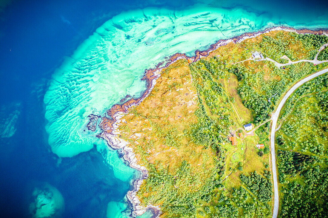 Road crossing the green landscape of Bergsoyan Islands washed by crystal sea from above, Skaland, Senja, Troms county, Norway