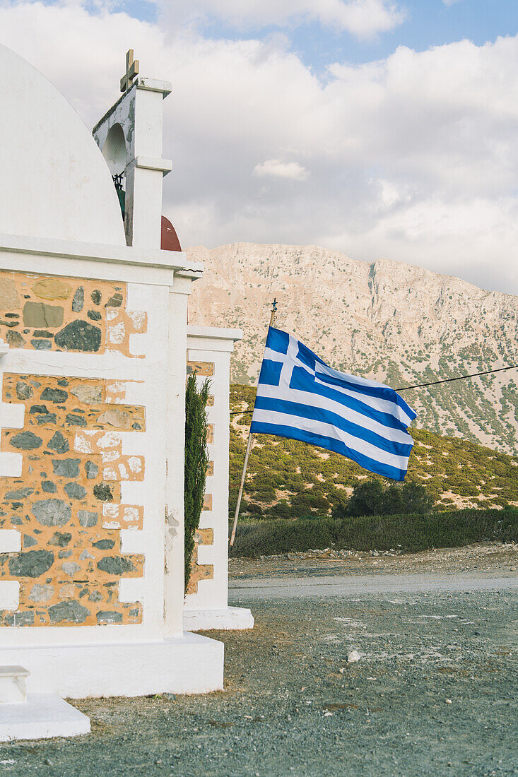 Die griechische Flagge hängt an der griechisch-orthodoxen Kirche Agia Fotini, Pachia Ammos, Kreta, Griechenland