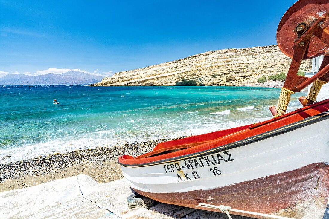 Fischerboot mit majestätischen Klippen im Hintergrund, Matala, Kreta, Griechenland