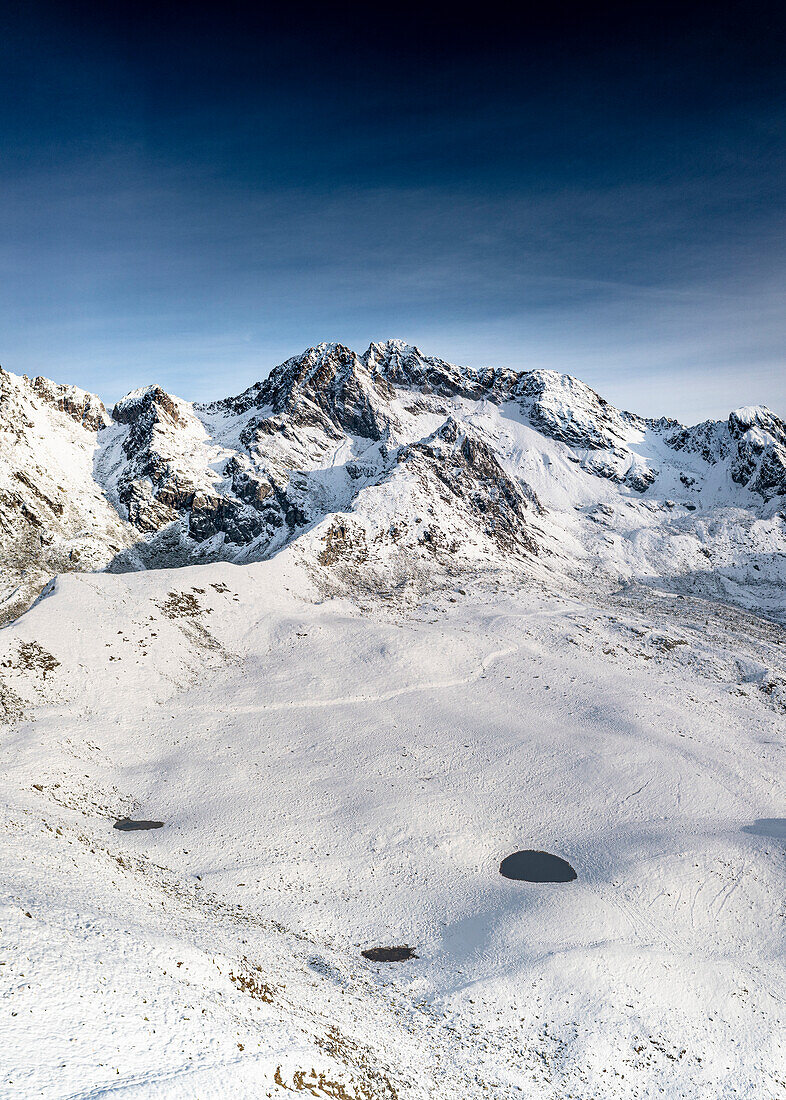 Luftaufnahme des majestätischen schneebedeckten Gipfels der Vetta di Rhon im Herbst, Piani di Rhon, Rätische Alpen, Sondrio, Lombardei, Italien