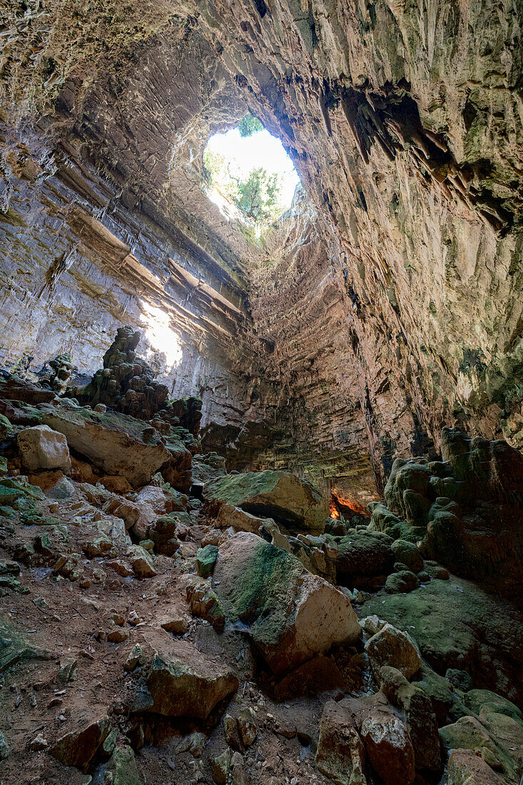Lichtstrahl filtert entlang des vertikalen Tunnels in den Grotten von Castellana (Grotte di Castellana), Provinz Bari, Apulien, Italien