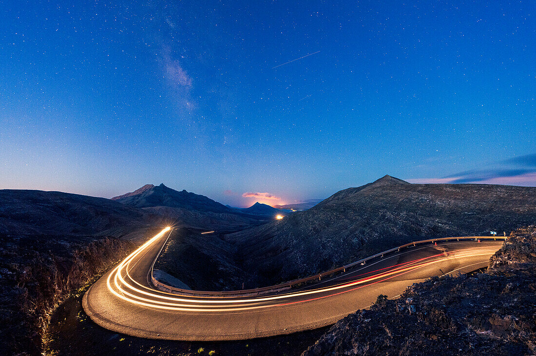 Dusk over the lights trails of car traveling on empty mountain road, Fuerteventura, Canary Islands, Spain