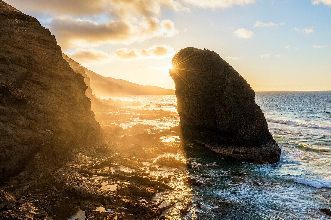 Sonnenuntergang über der Felsformation Roque Del Moro im rauen Meer, Strand von Cofete, Jandia, Fuerteventura, Kanarische Inseln, Spanien