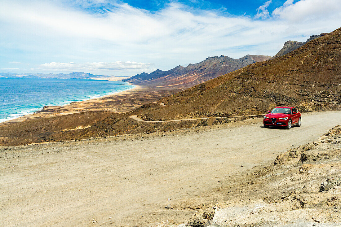 Car traveling on desert road to Cofete Beach, Jandia natural park, Fuerteventura, Canary Islands, Spain
