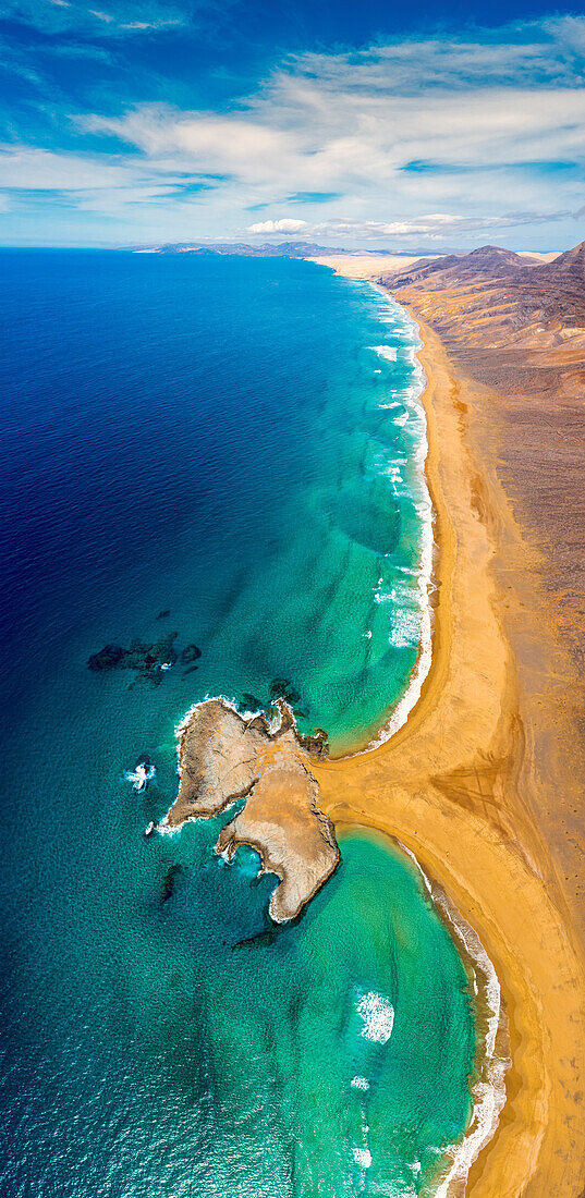 Aerial view of El Islote rock islet along the desert Cofete Beach, Jandia peninsula, Fuerteventura, Canary Islands, Spain