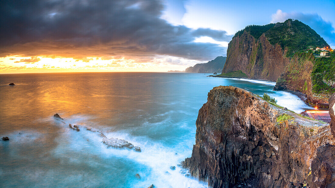 Sonnenaufgang über den Wellen, die an die majestätischen Felsenklippen schlagen, Insel Madeira, Portugal