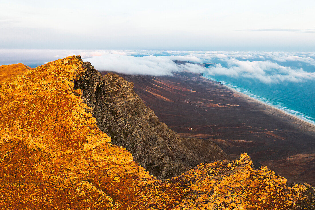 Luftaufnahme des Gipfels Pico de la Zarza in der Morgendämmerung mit dem Strand von Cofete und dem Meer im Hintergrund, Fuerteventura, Kanarische Inseln, Spanien