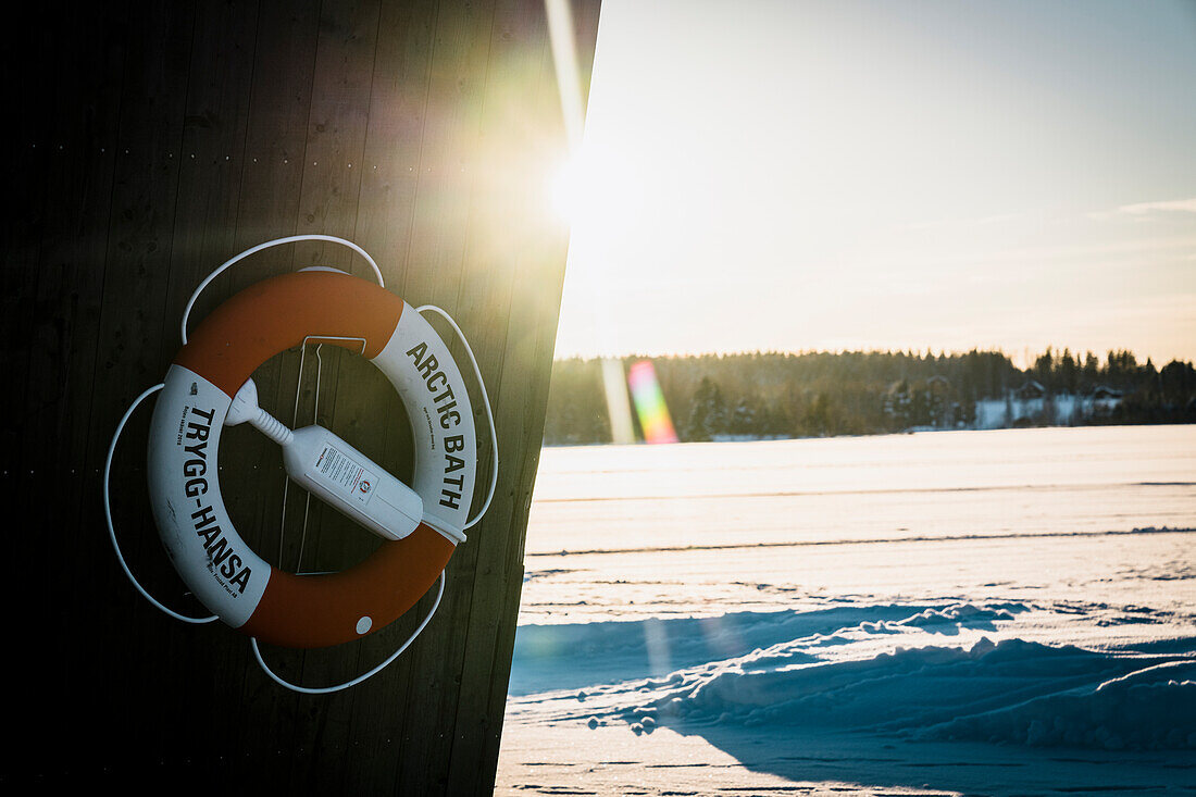 Rettungsboje aus einer Holzhütte im Licht des Sonnenuntergangs im Winter, Arctic Bath Hotel, Harads, Lappland, Schweden