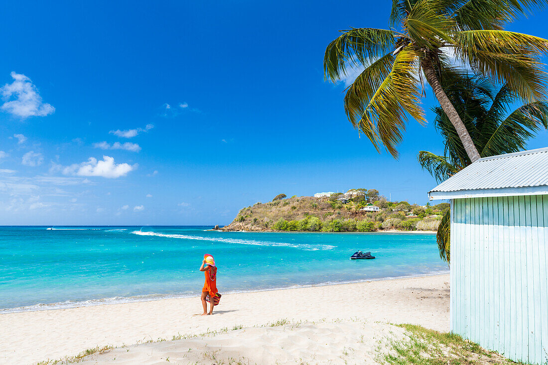 Frau bewundert das kristallklare Meer an einem tropischen Strand, Antigua, Leeward Islands, Karibik, Westindische Inseln