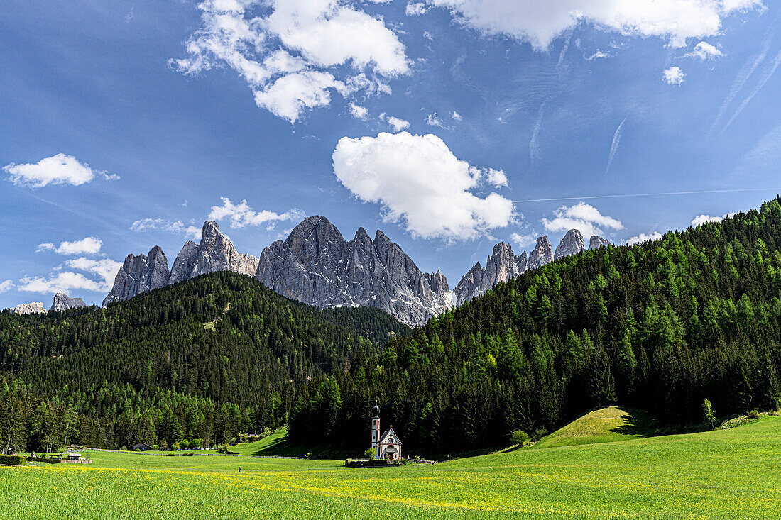 The iconic church of San Giovanni (St. John) in Ranui with majestic Odle peaks in background, Funes Valley, South Tyrol, Italy