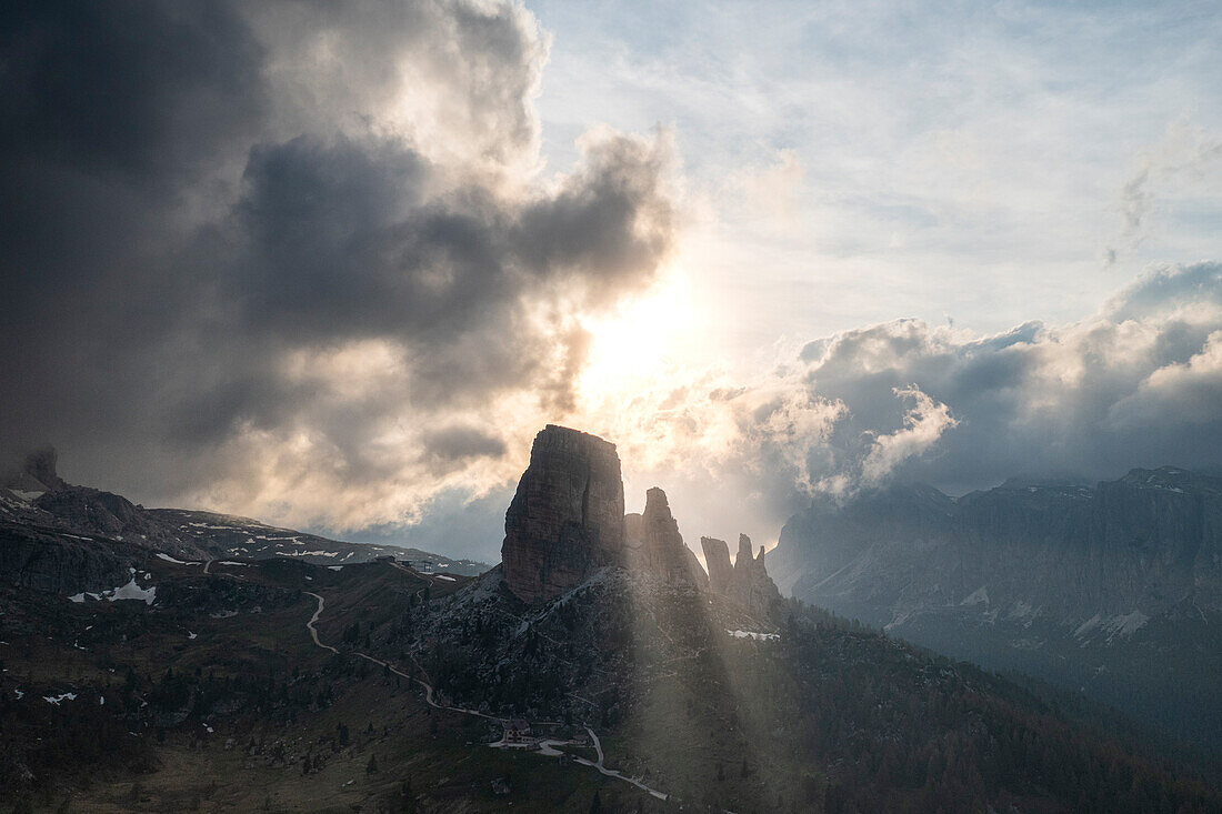 Cinque Torri mountains lit by sun rays in the cloudy sky at sunset, Dolomites, Belluno province, Veneto, Italy