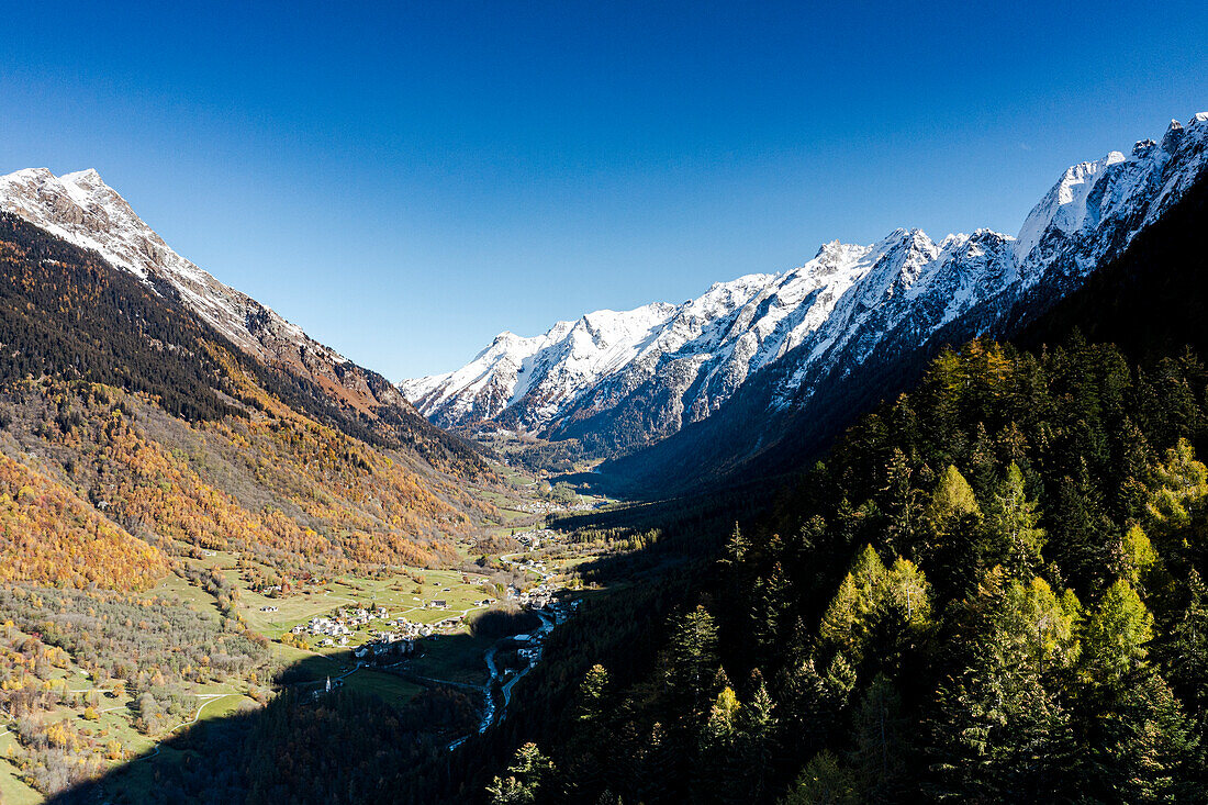 Schneebedeckte Berge rund um die Dörfer Borgonovo und Vicosoprano im Herbst, Val Bregaglia, Kanton Graubünden, Schweiz