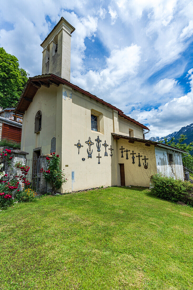Sommerhimmel über der alten Bergkirche, umgeben von grünen Wiesen, Crana, Piuro, Valchiavenna, Valtellina, Lombardei, Italien