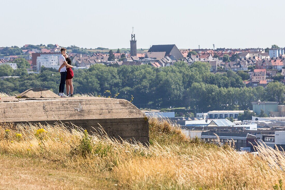 Young couple sitting over the sea on the beach of boulogne sur mer, (62) pas-de-calais, france