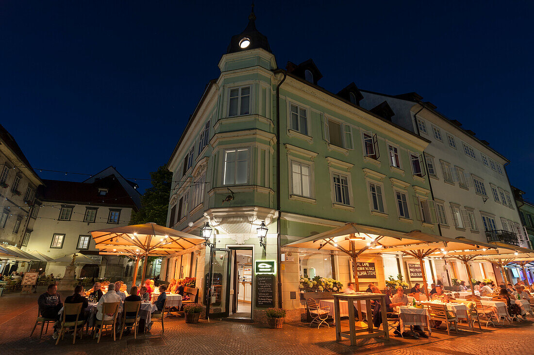 Straßencafés und Restaurants entlang des Flusses Ljubljanica bei Nacht, Ljubljana, Slowenien.