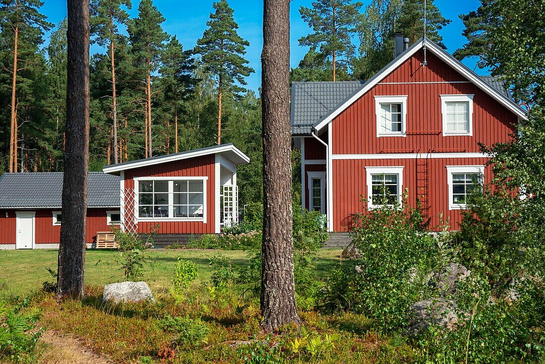 Typisches Holzhaus im Dorf Nagu oder auf der Insel Nauvo in Väståboland in Pargas im südwestfinnischen Schärengebiet von Turku. Die Schärenringstraße oder Saariston rengastie ist voll von Dingen, die man sehen, tun und unternehmen kann. Der Schärenweg kann im oder gegen den Uhrzeigersinn befahren werden. Er beginnt in der historischen Stadt Turku und führt durch ländliche Schärendörfer und erstaunliche Ostseelandschaften. Der Weg kann von Anfang Juni bis Ende August begangen werden.