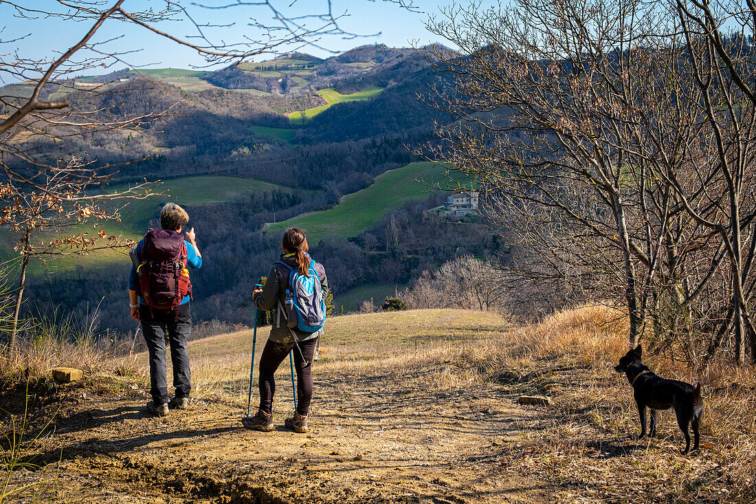 Zwei Frauen mit Rucksack und Hund bewundern den Apennin. Modigliana, Forlì, Emilia Romagna, Italien, Europa.