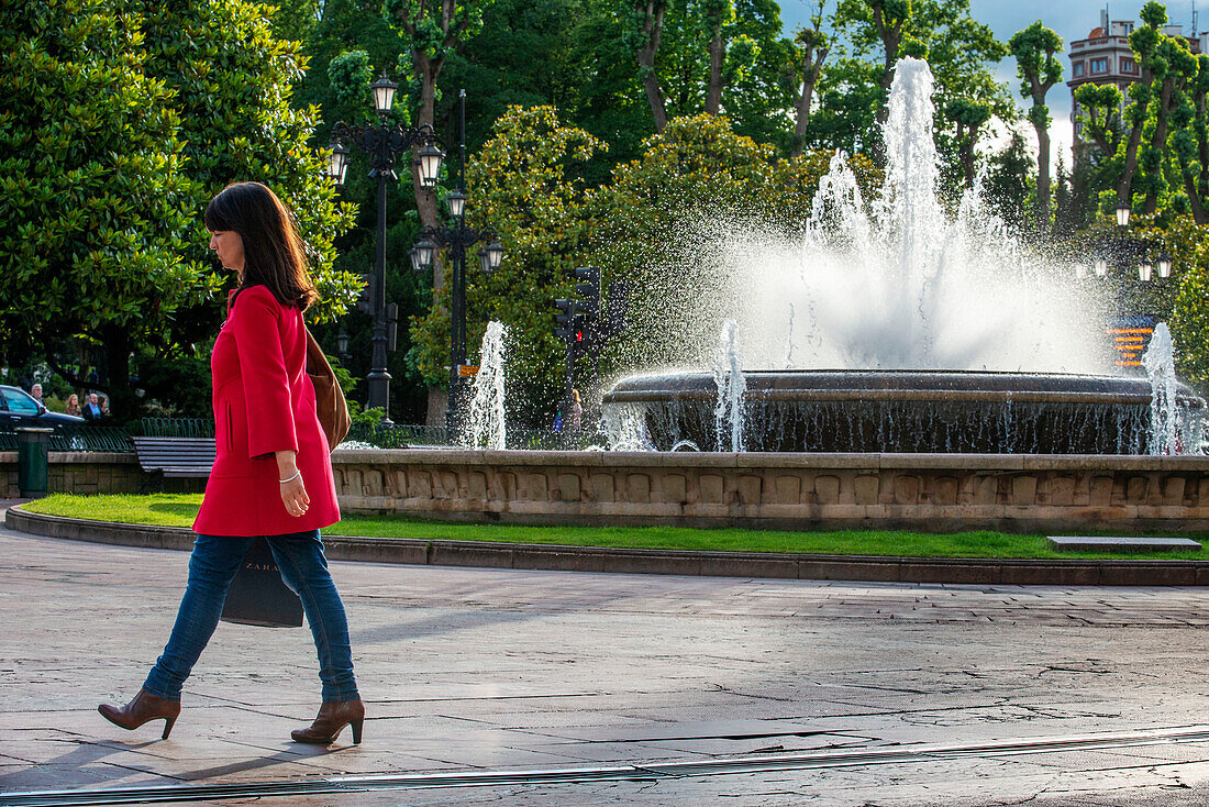 Frau in Rot im Brunnen auf der Plaza de la Escandalera in Oviedo in der Region Asturien, Spanien