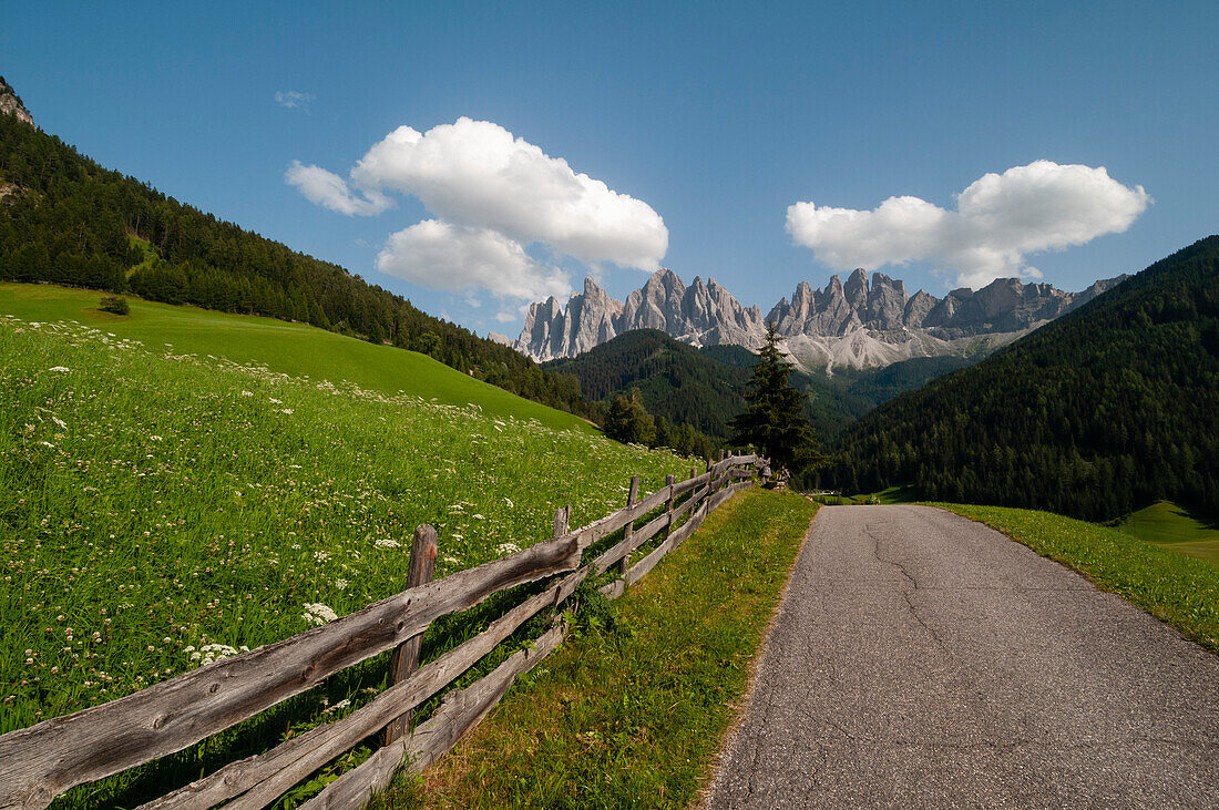 Eine Straße im Funes-Tal, die zum Berg der Geislergruppe führt. Funes, Trentino Südtirol, Italien.