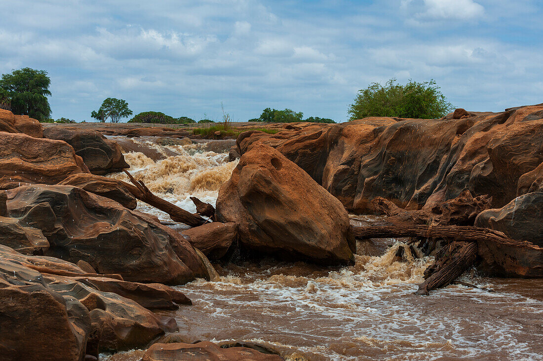 Die Lugard-Fälle, felsige Ufer und Felsbrocken im Galana-Fluss. Lugard-Fälle, Galana-Fluss, Tsavo-Ost-Nationalpark, Kenia.