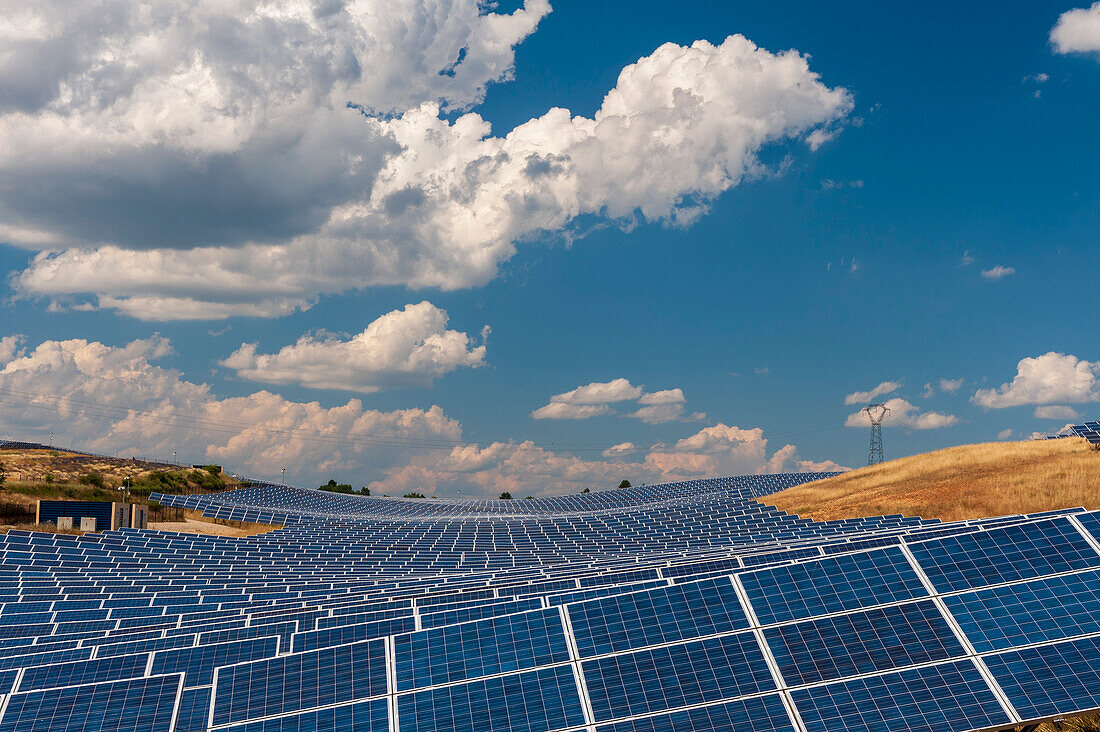 A field of solar panels at a solar power plant, under a cloud-filled sky. Les Mees, Provence, France.