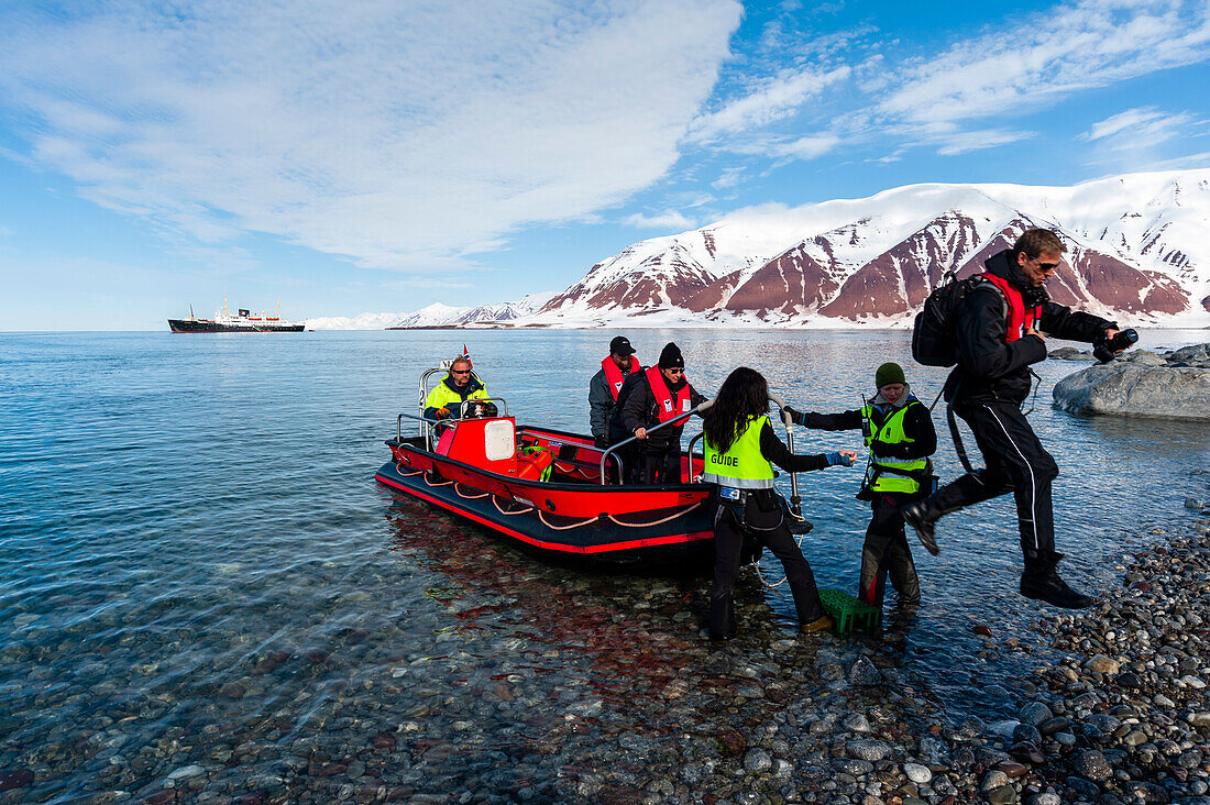 Touristen steigen von einem Schlauchboot am Ufer des Bockfjordens aus. Bockfjord, Insel Spitzbergen, Svalbard, Norwegen.