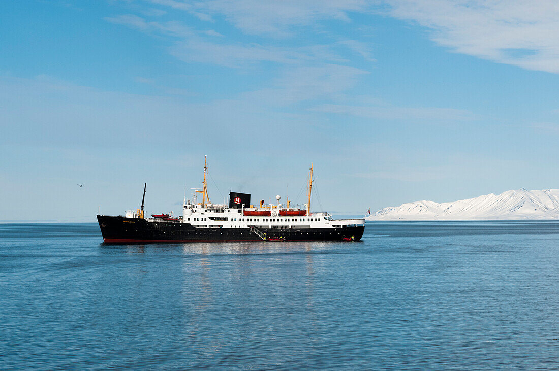 An expedition cruise ship anchored in Bockfjord's arctic waters. Bockfjorden, Spitsbergen Island, Svalbard, Norway.