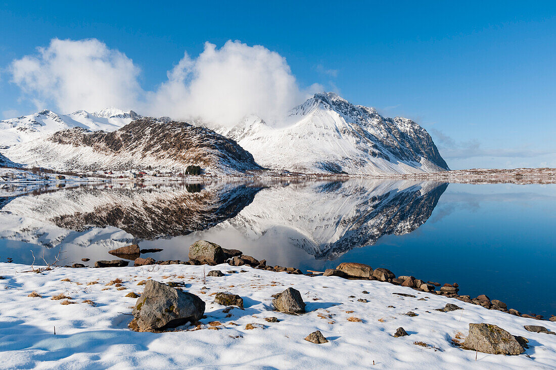 Mountains reflect into the calm water of a lake. Eggum, Lofoten Islands, Nordland, Norway.