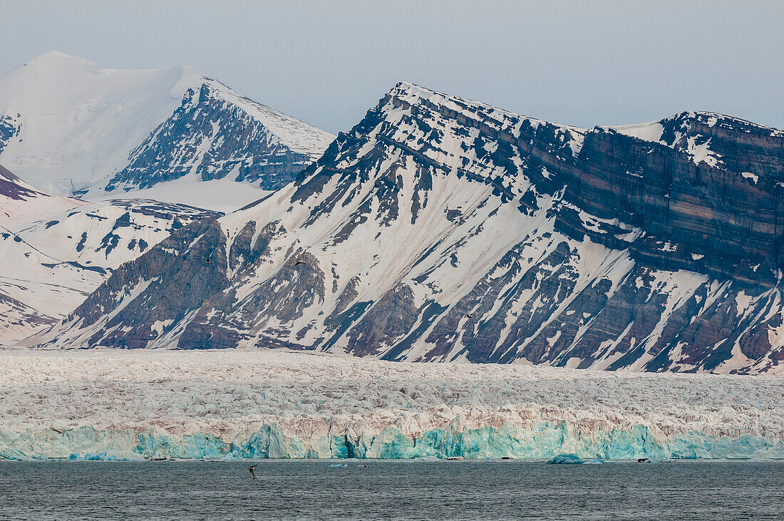 Eisbedeckte Berge und ein Gletscher begrenzen den Kongsfjorden bei Ny-Alesund. Ny-Alesund, Kongsfjorden, Insel Spitzbergen, Svalbard, Norwegen.