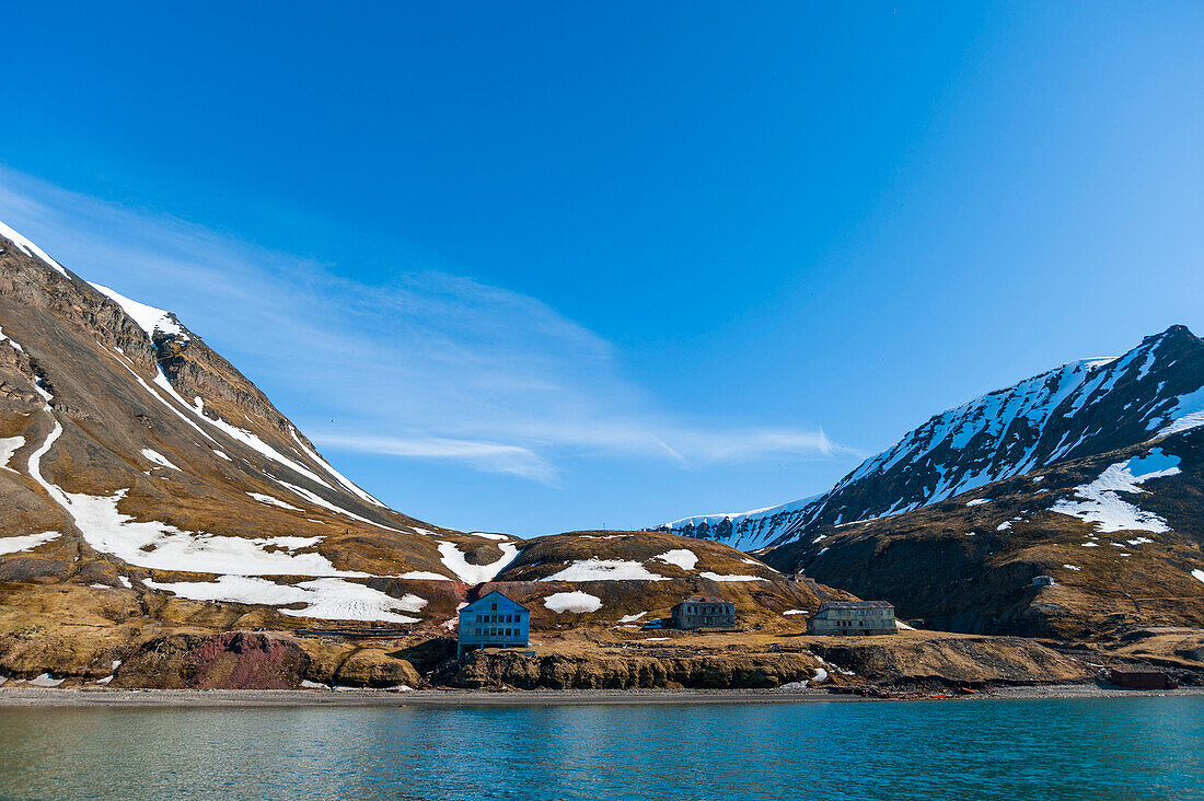 An old settlement nestled among cliffs near Longyearbyen on the bay of Adventfjorden. Longyearbyen, Spitsbergen Island, Svalbard, Norway.