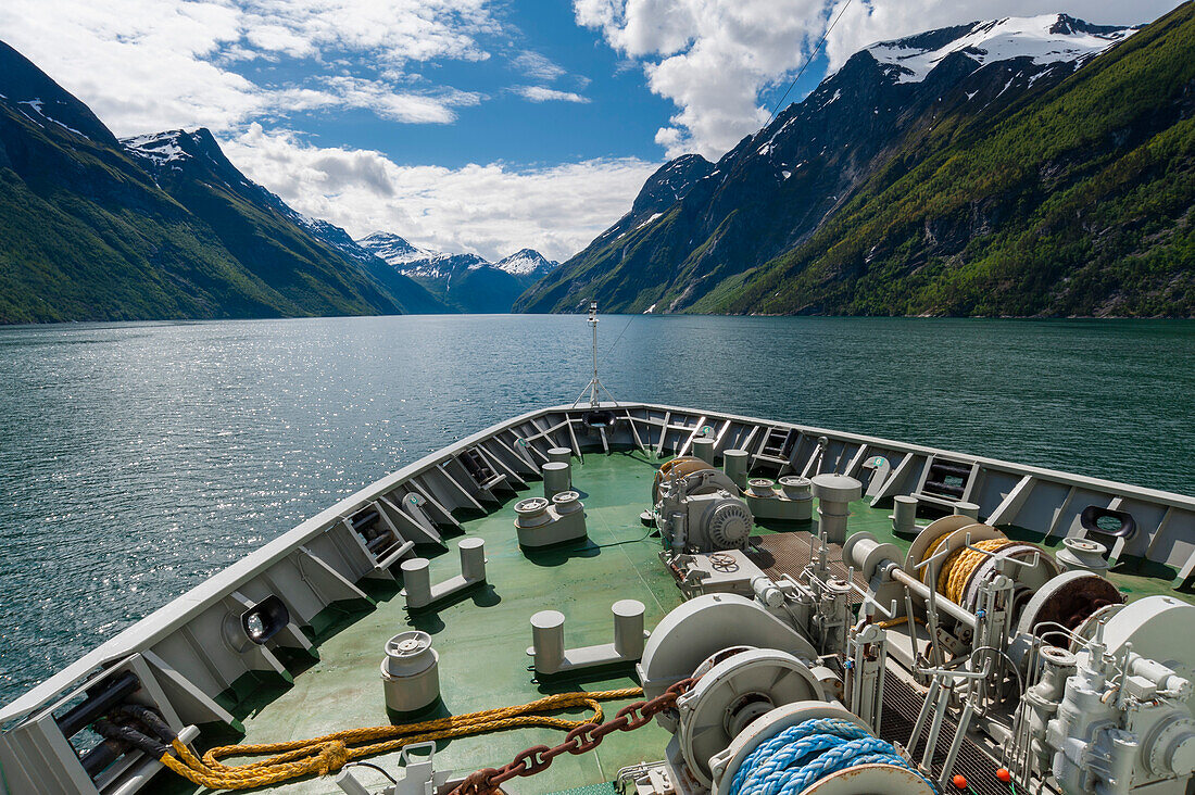 The MS Nordlys cruise ship navigates arctic waters in Geirangerfjord. Geirangerfjord, Norway.