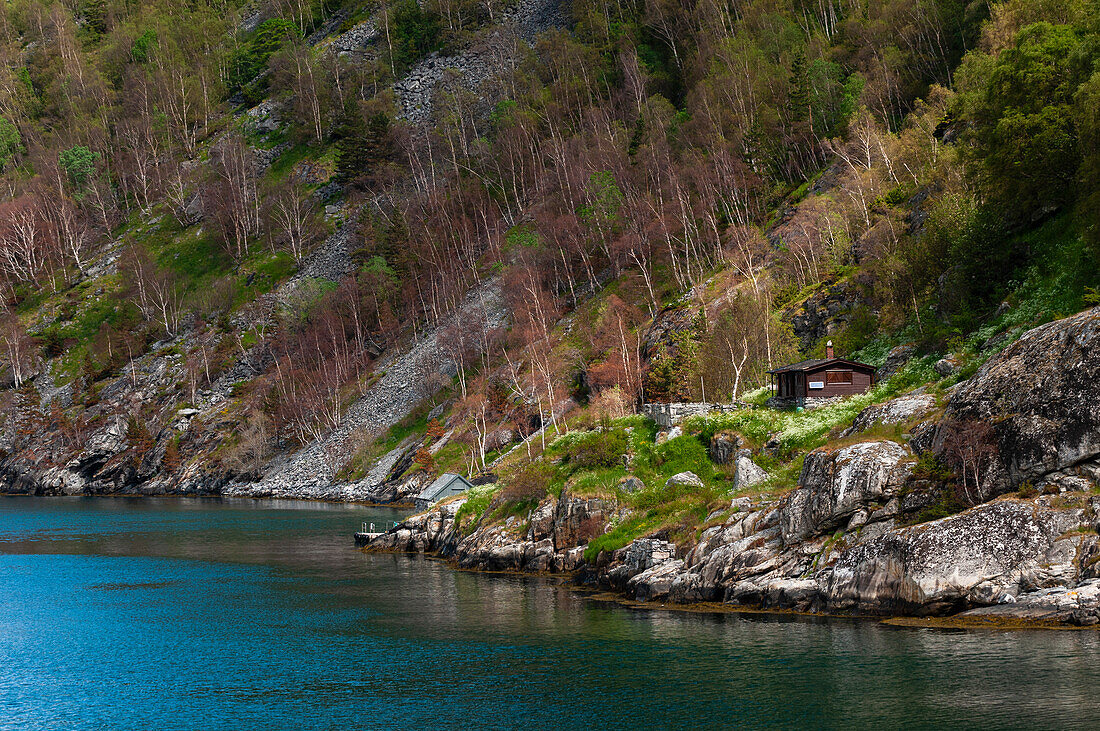 Häuser an steilen, zerklüfteten Klippen über dem Geirangerfjord. Geiranger, Geirangerfjord, Norwegen.