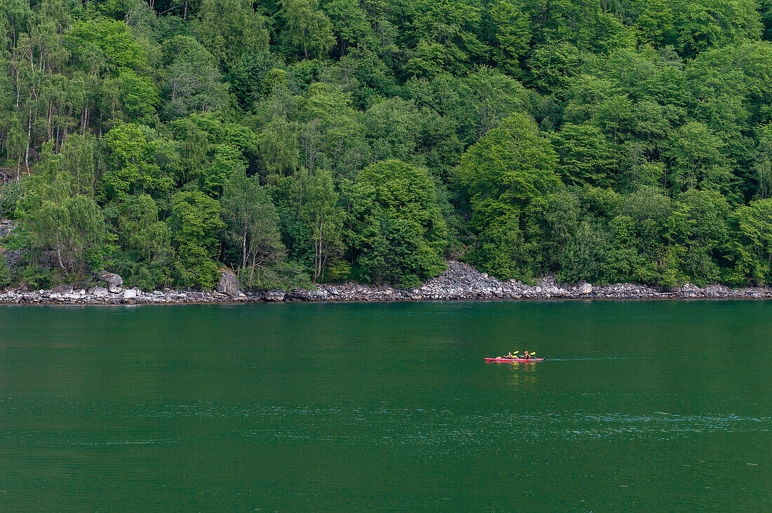 Kayakers enjoy the natural beauty of Geirangerfjord. Geirangerfjord, Norway.