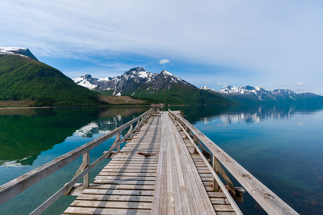 Eine Anlegestelle am Holandsfjord, umgeben von eisbedeckten Bergen, in der Nähe des Svartisen. Saltfjellet Svartisen-Nationalpark, Svartisen, Norwegen.