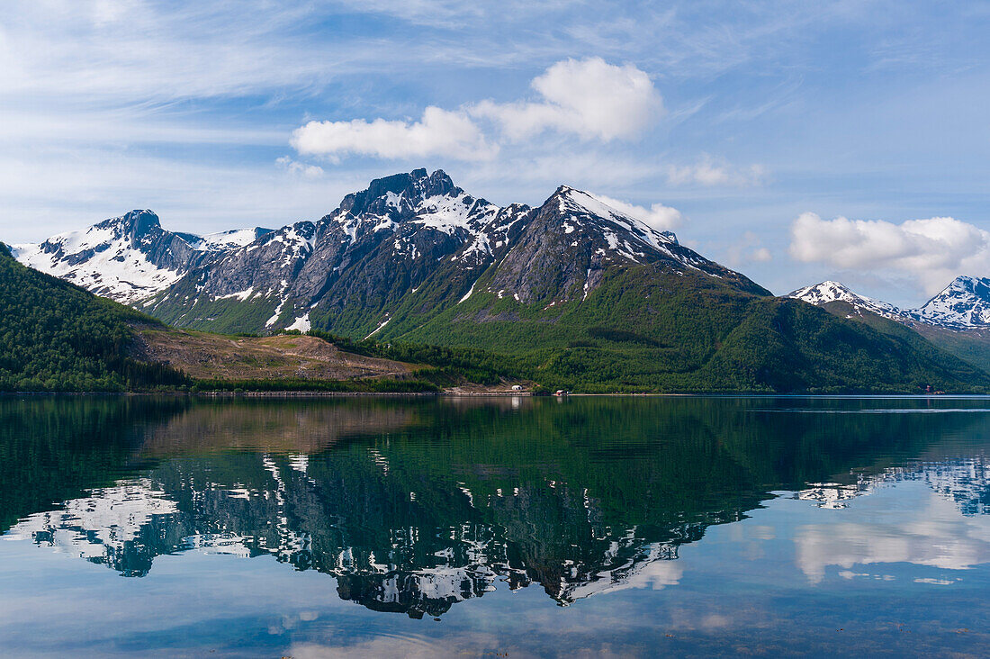 Eisbedeckte Berge spiegeln sich im Holandsfjorden in der Nähe des Svartisen-Gletschers. Saltfjellet Svartisen-Nationalpark, Svartisen, Norwegen.