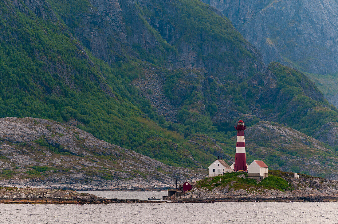 Der Leuchtturm von Landegode auf einer kleinen, von steilen Bergen umgebenen Insel im Vestfjord. Landegode, Vestfjorden, Norwegen.