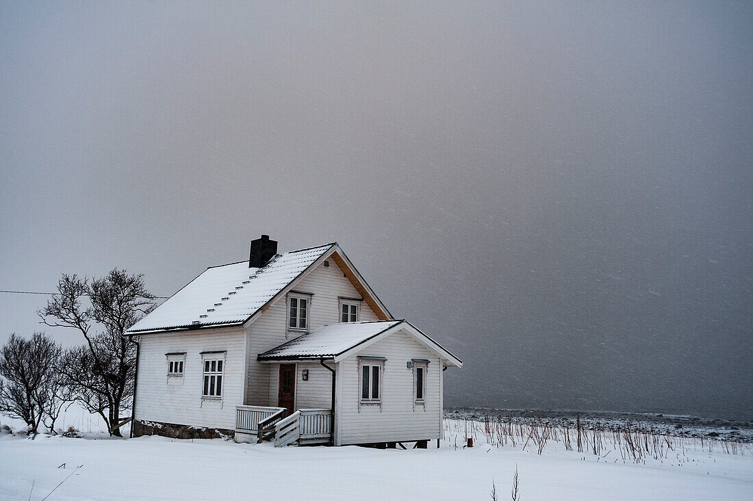 Ein Haus am Meer während eines Schneesturms. Bo, Vesteralen-Inseln, Nordland, Norwegen.