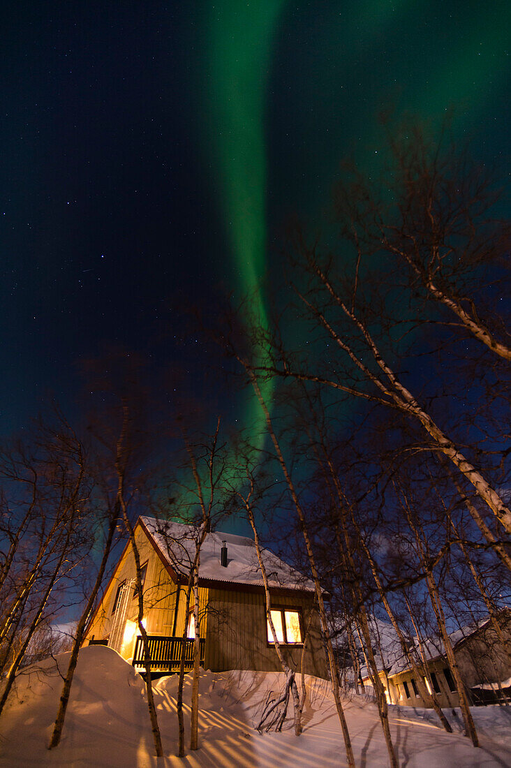 Ein Polarlicht über der Hütte der Abisko Turiststation, Abisko National Park, Schweden.
