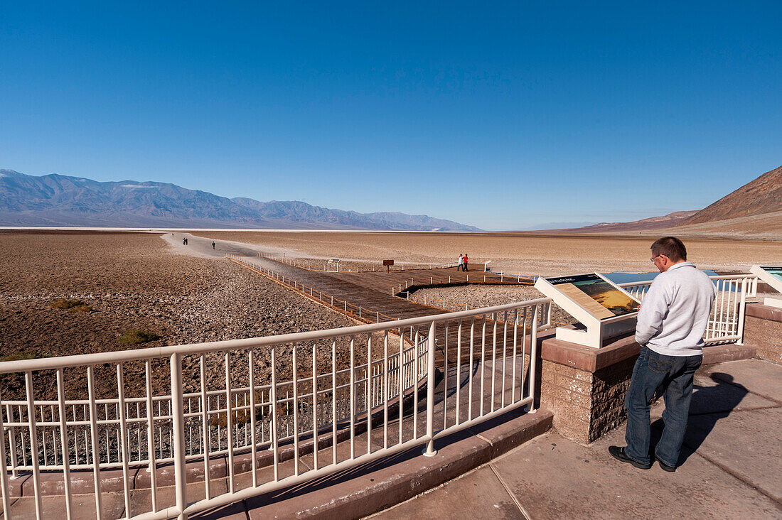 A tourist at the observation deck of Badwater Basin. Death Valley National Park, California, USA.