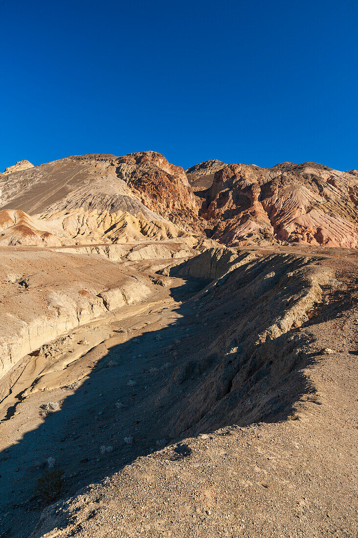 Shadows across rock formations in the badlands of Artist's Drive in Death Valley. Death Valley National Park, California, USA.