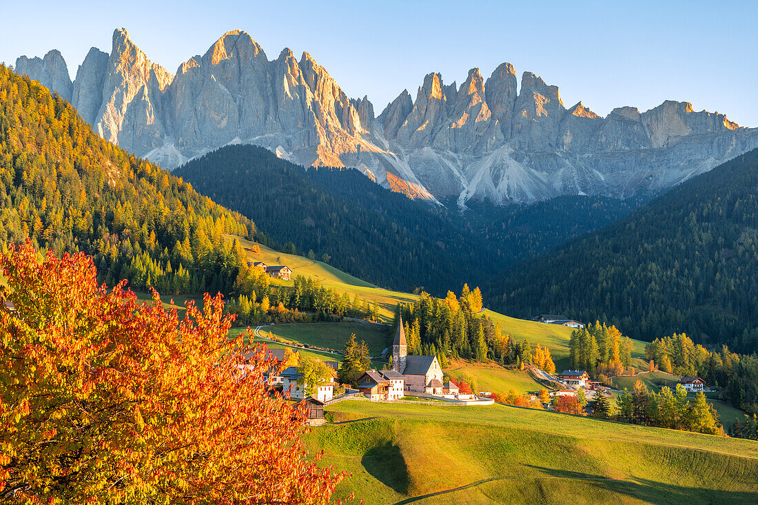 Blick auf das Dorf St. Magdalena mit der Geislergruppe im Hintergrund. Funes-Tal, Südtirol, Italien.